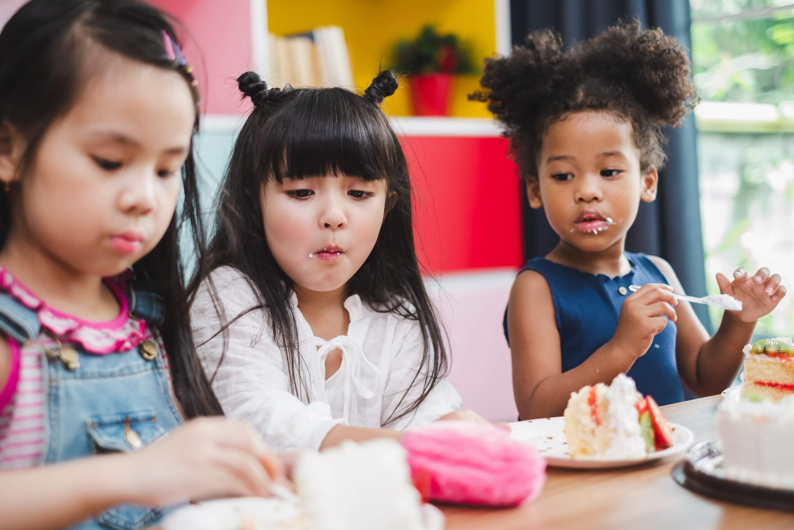 Three children at a table working on an art project.