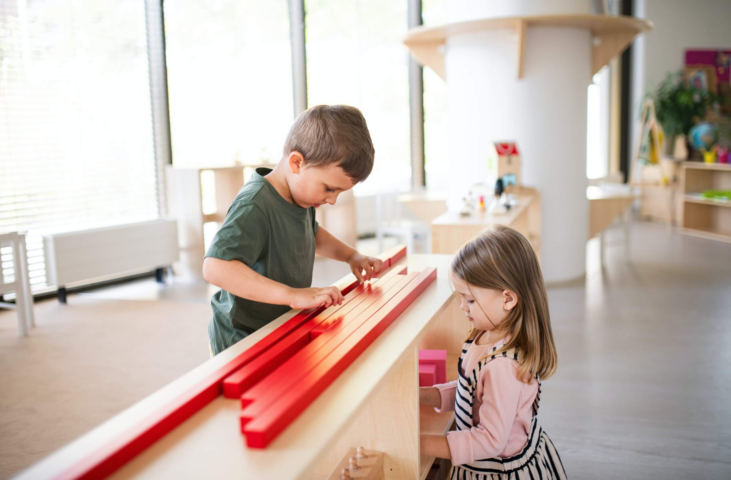 A boy and a girl playing together with blocks