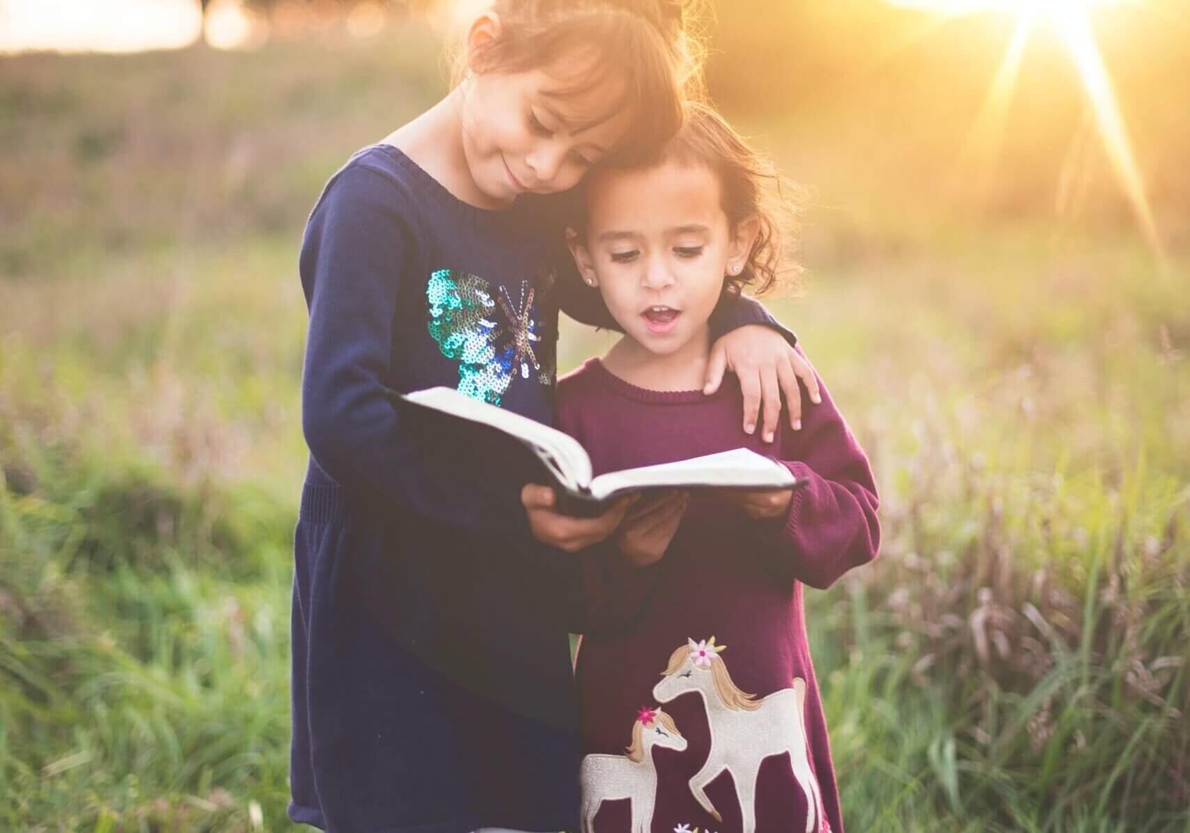 Two children hugging and reading a book