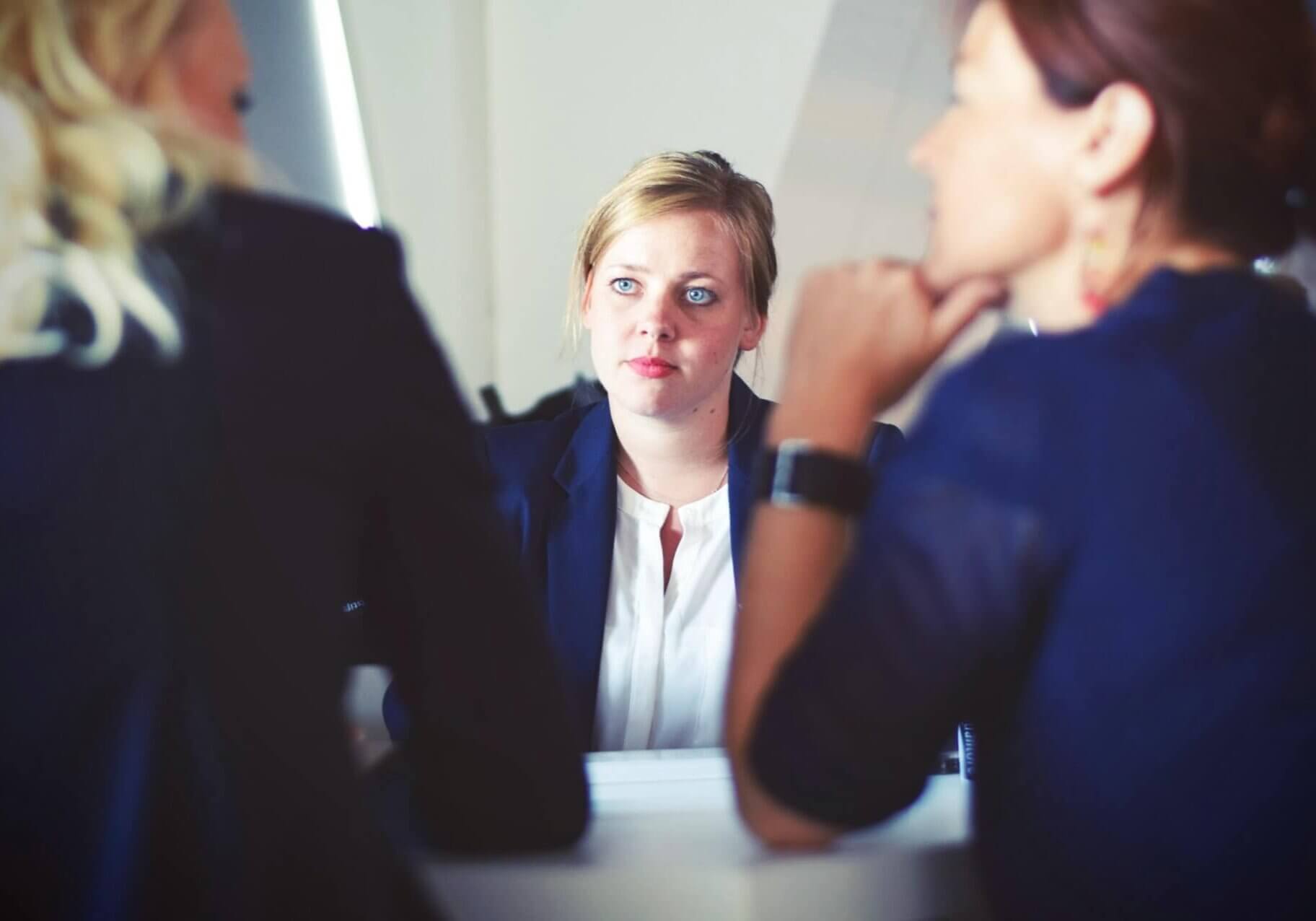 A woman sitting across the a table from two women